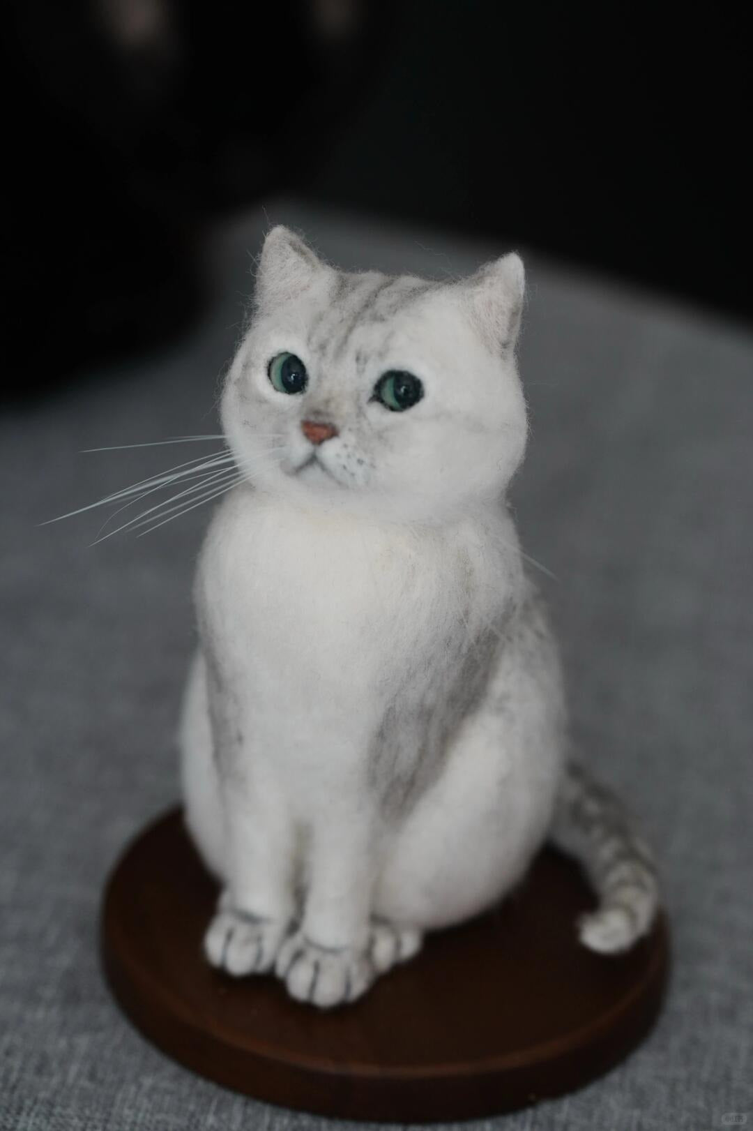 White cat figurine on a gray surface