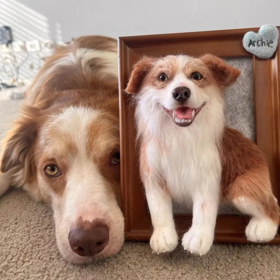 Dog looking at a photo frame with a smaller dog inside, both on a carpeted floor.