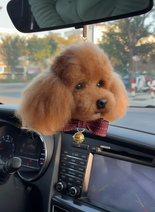 Brown dog-shaped car air freshener hanging from a car's rearview mirror.