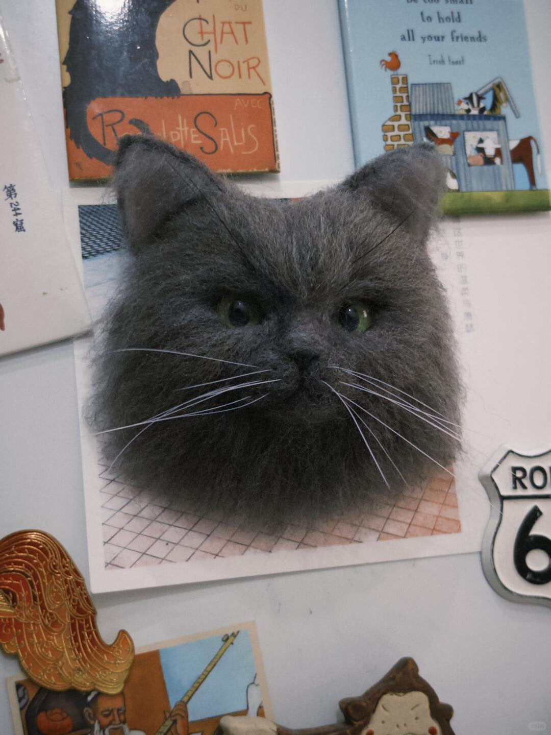 Gray cat with a vintage-style background featuring posters and a 'Route 66' sign.