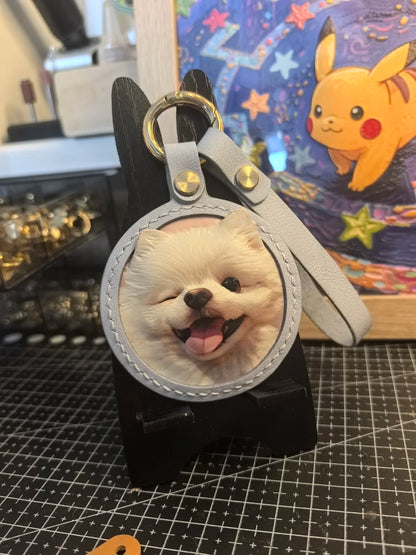 Keychain with a dog's face on a black surface with a colorful background featuring a cartoon character.