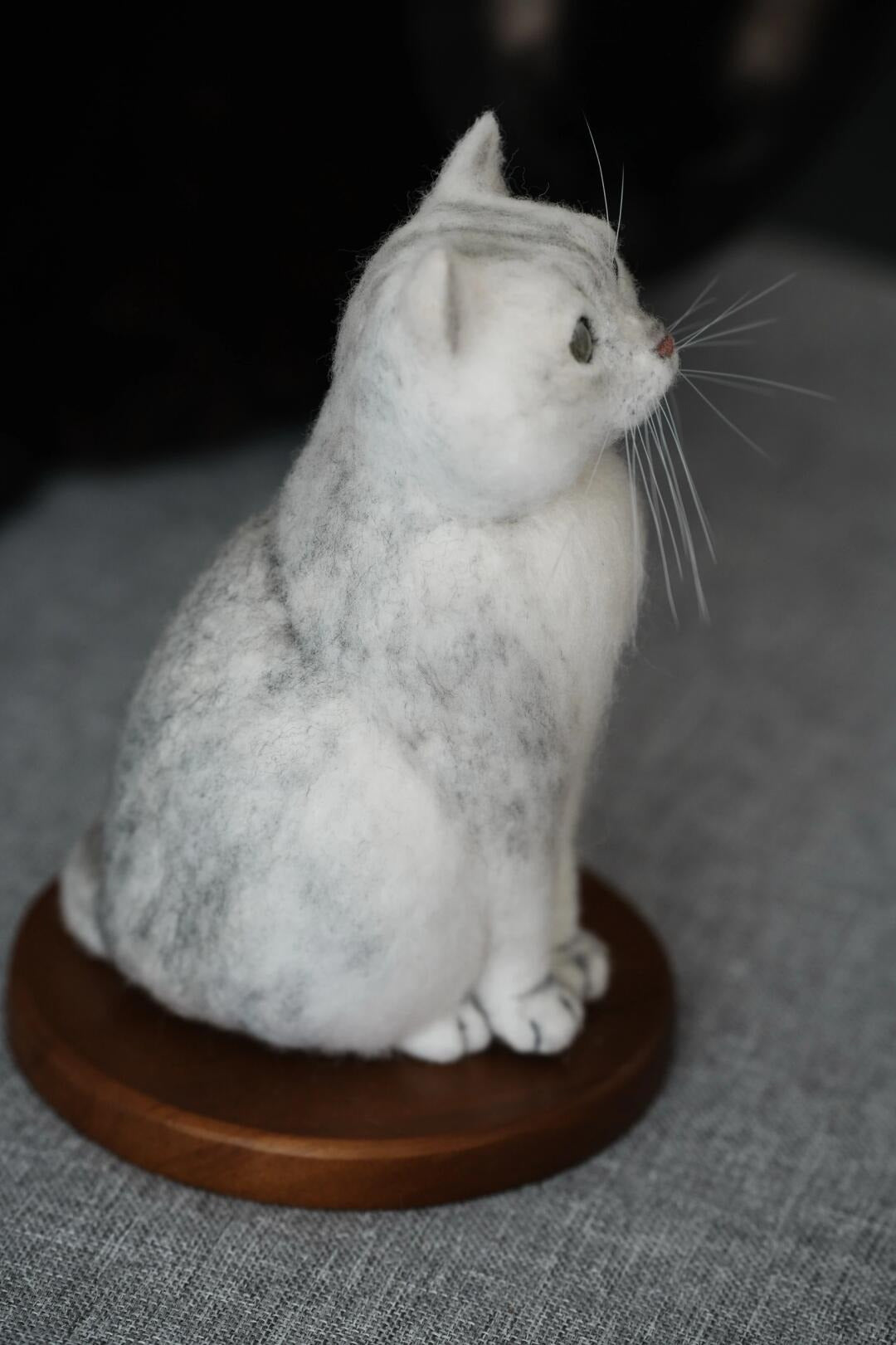 Felted cat sculpture on a wooden base