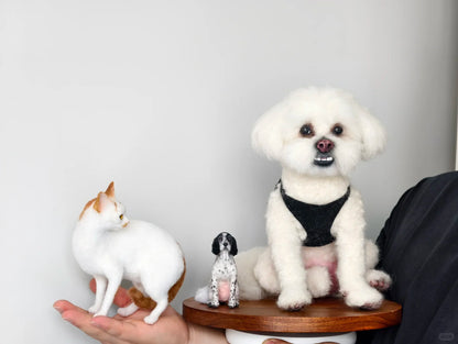 Small white dog and cat figurines on wooden stands against a plain background