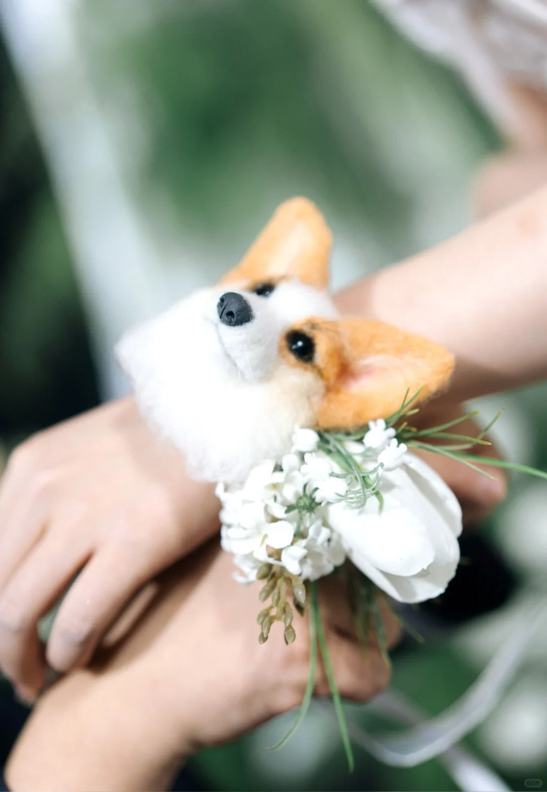 Floral arrangement shaped like a dog held by a person with a blurred green background