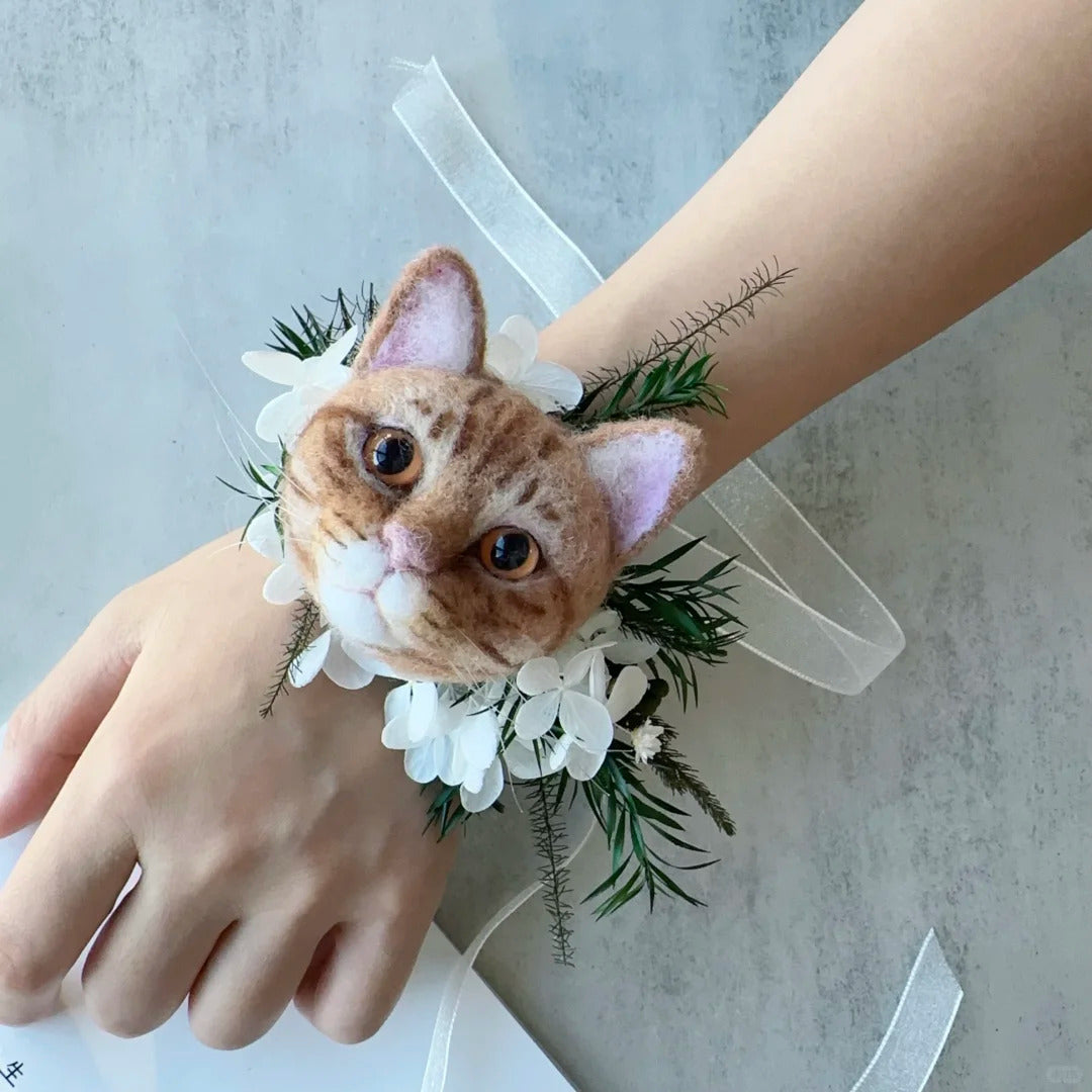 Cat-shaped wrist corsage with floral details on a wrist against a light background