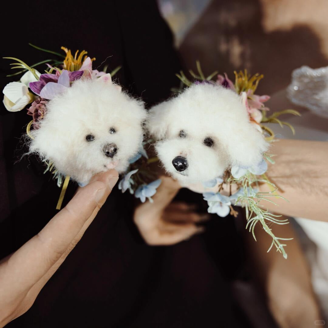 Two small white teddy bears with floral decorations held by a person.